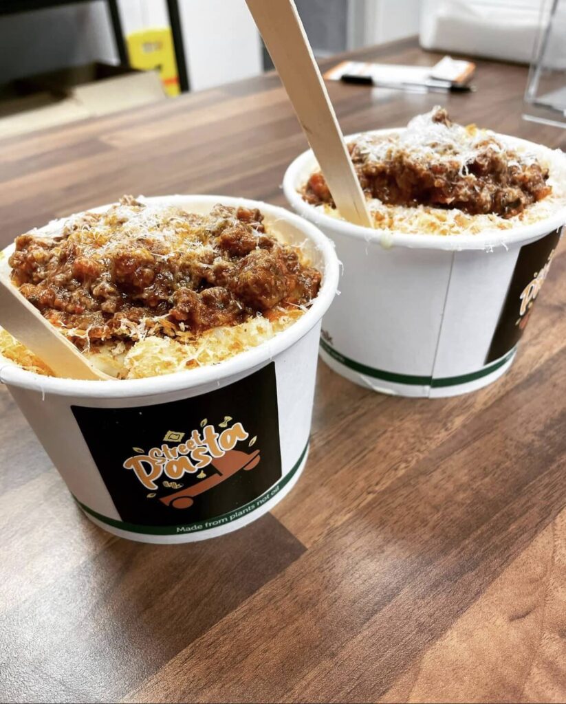 Street Pasta bowls topped with sauce and fresh herbs